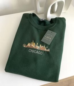 A green sweatshirt with the skyline of Chicago embroidered