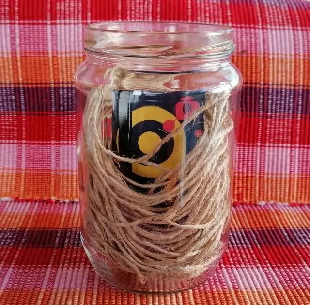 A mason jar filled with jute rope and a gift