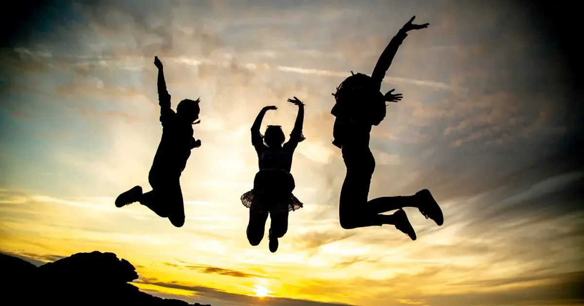 silhouette of teenagers jumping in the air at