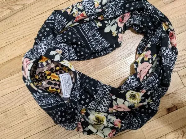 An infinity scarf with a floral print and a hidden pocket