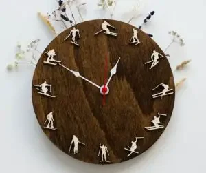 A wooden wall clock with skier figurines instead of numbers