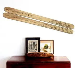 A pair of wooden skies with a family name hanging on a wall