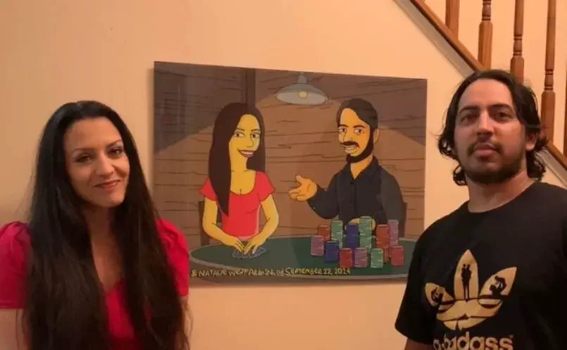 Photo of two people with a caricature poster of themselves