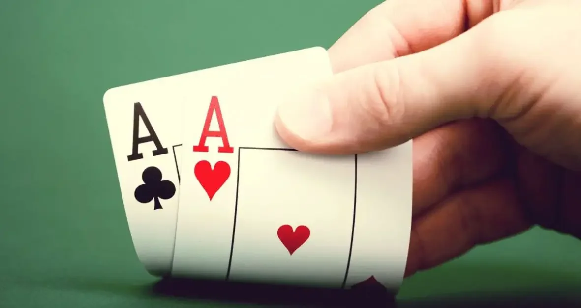 A hand holding two cards