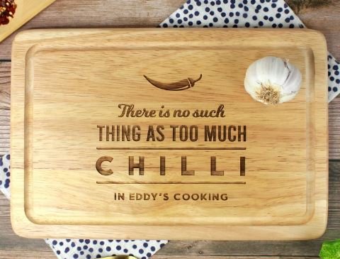 Chopping board with text etched "there is no such thing as too much chilli in Eddy's cooking"