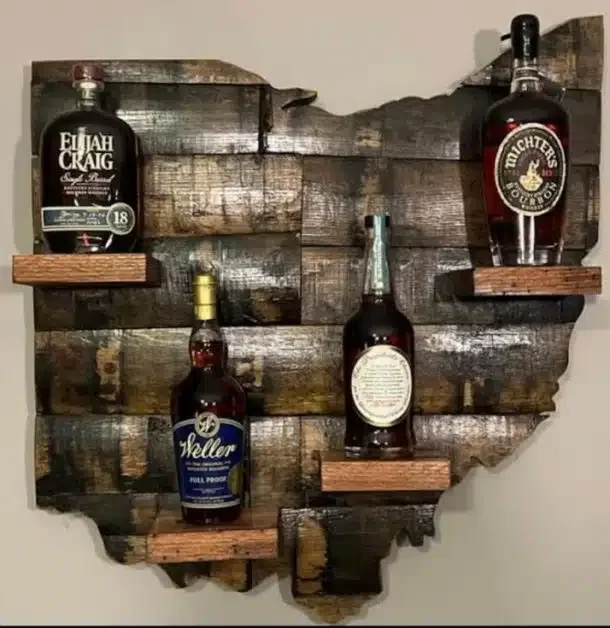 Wooden wall art in the shape of Ohio map with bottles of whiskey