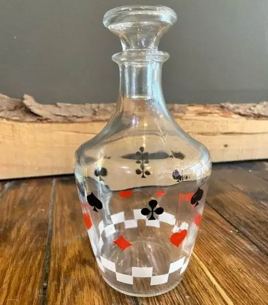 A glass decanter with a card theme