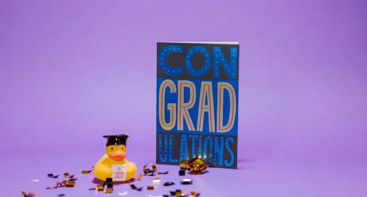 Card with "ConGRADulations" and a rubber duck wearing a graduation hat