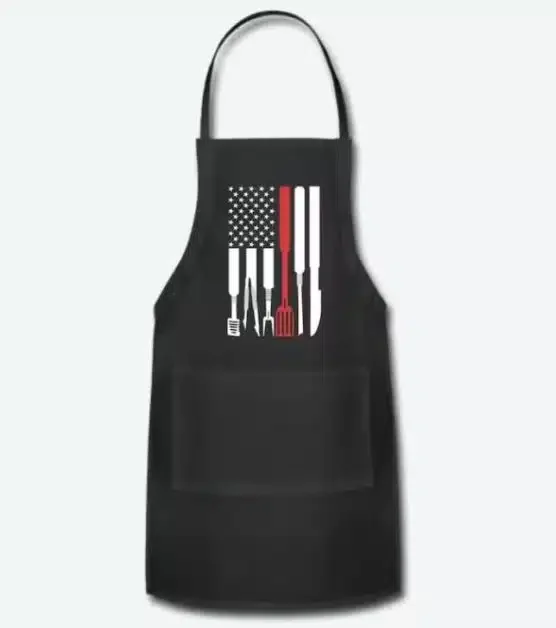 Black apron with the flag of the US depicted in grill utensisls