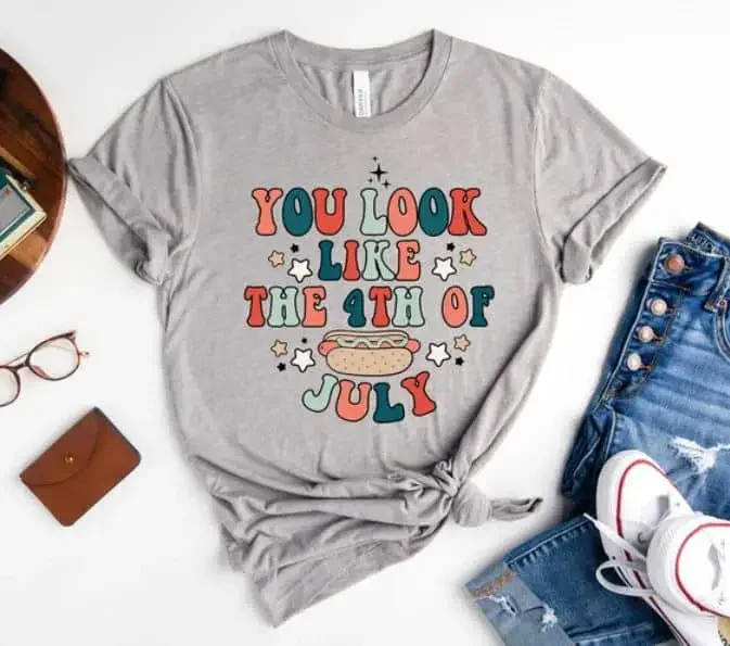 A grey t-shirt with the text "You look like the 4th of July" and an icon of a hotdog