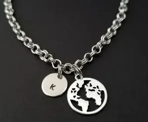 Bracelet with a letter K pendant and a pendant of a world map