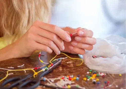 Child making jewelry with beads