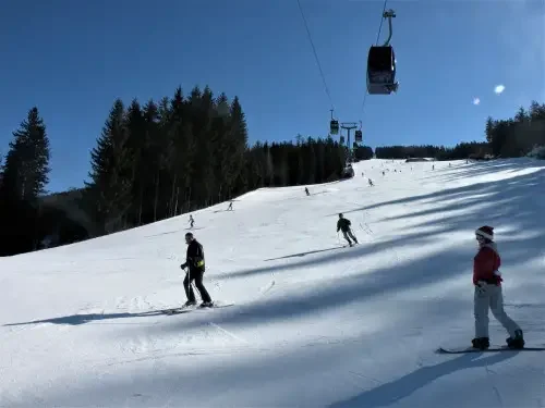 People skiing and snowboarding down a slope