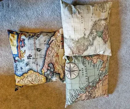 A set of three pillows with world maps