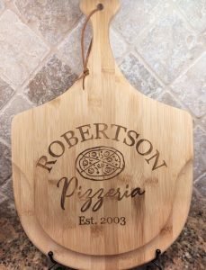 A wooden plate with "Robertson pizzeria" etched