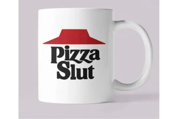 A white coffee mug with the text "pizza sl*t"