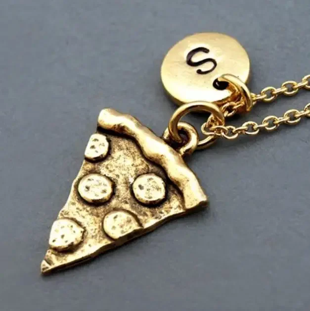 A golden necklace with a pendant of a slice of pizza