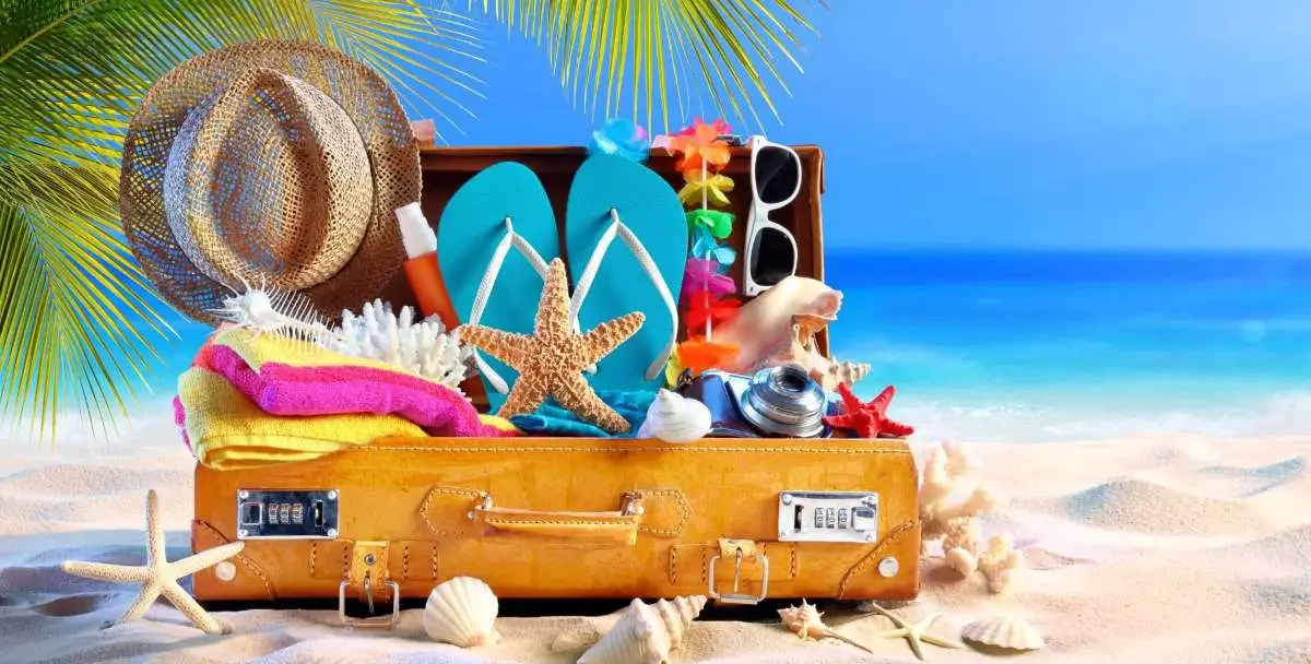 A suitcase filled with gifts and items at the beach