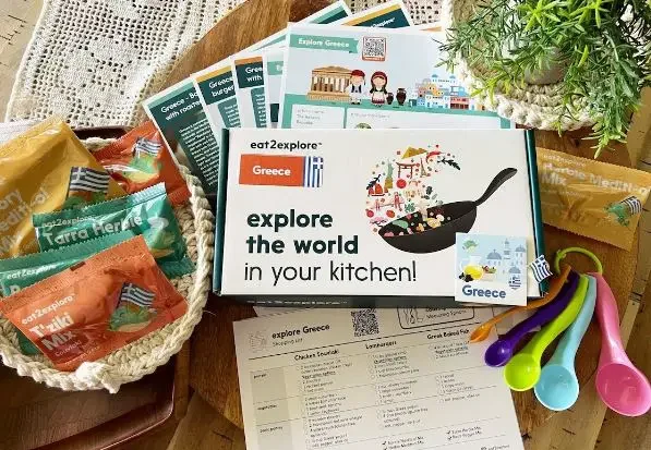 Box with "explore the world in your kitchen" and Greek-themed food items