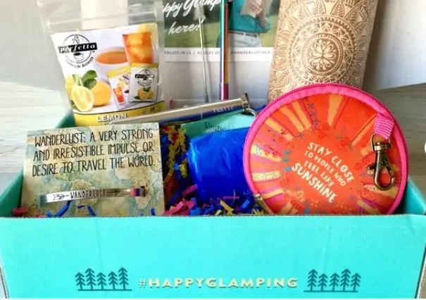 A box with "happy glamping" and gifts for campers