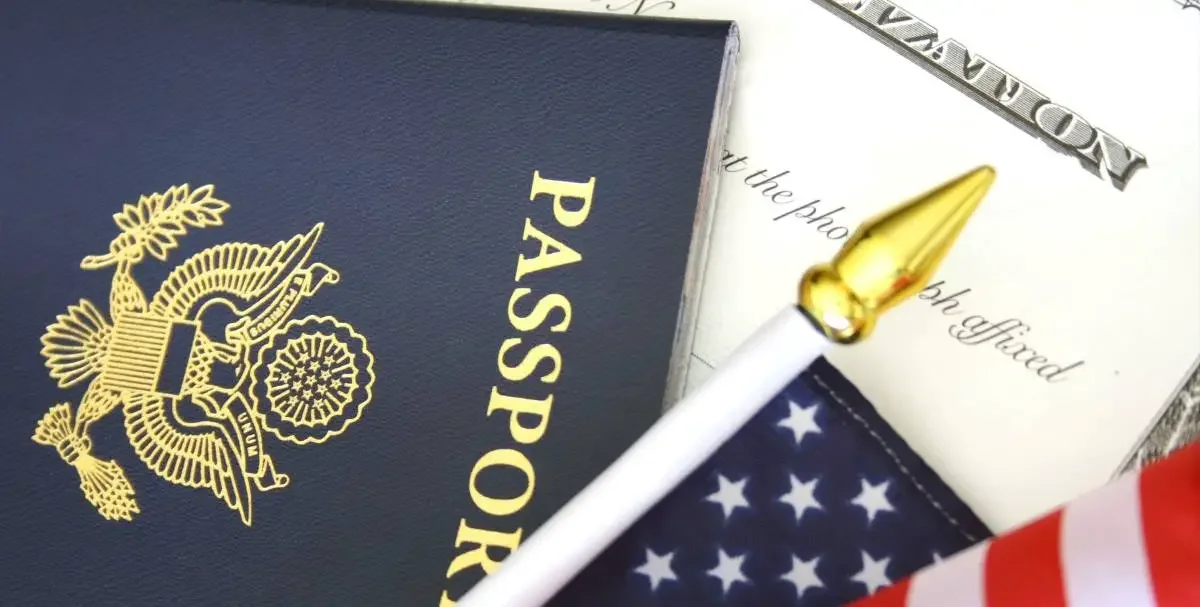 A photo of a US passport, US flag and an immigration form