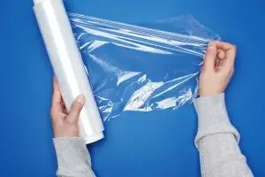 A roll of cling foil against a blue background