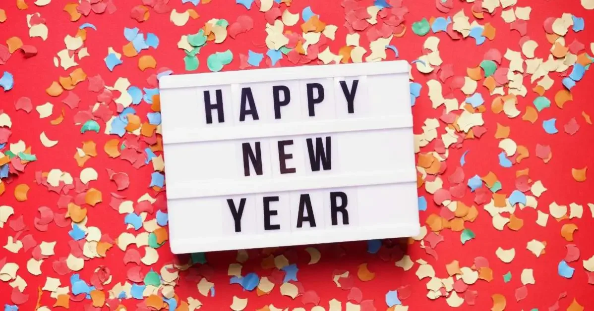 A sign with "happy new year" and colorful confetti