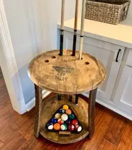 A pool balls and cue holder made from an old whiskey barrel