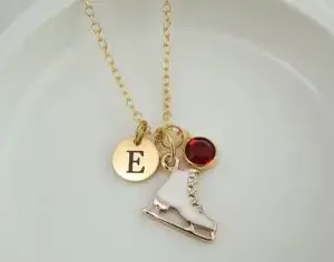 A necklace with a pendant of the letter E and an ice skate