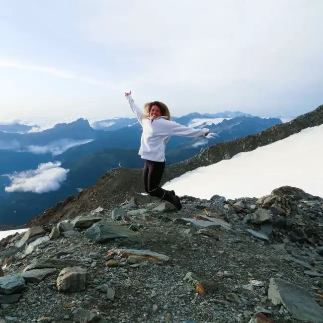 A woman jumping in the air on a mountain