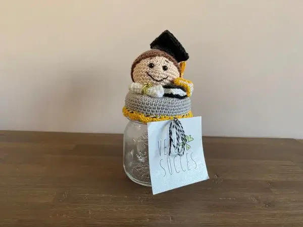 A jar with a crochet graduation hat