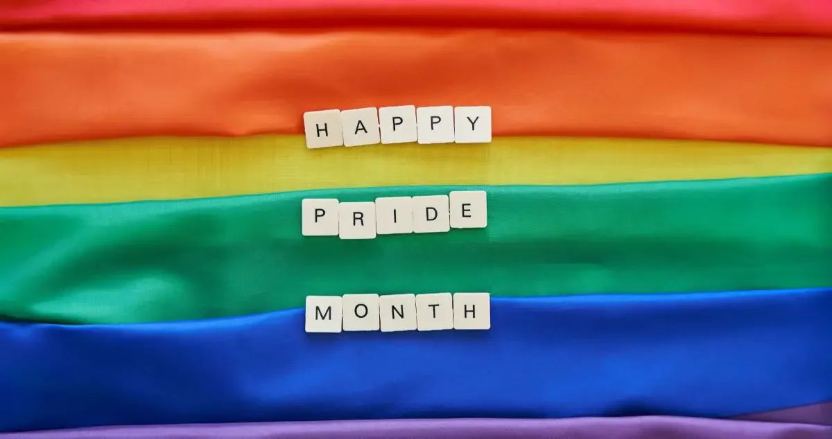 A rainbow flag and the text "happy pride month"