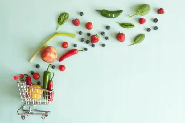 An image of a small grocery cart with veggies