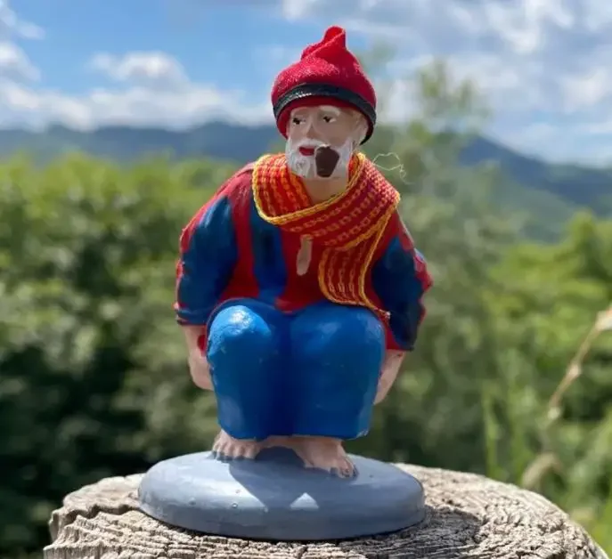A figurine of an old man in squat position