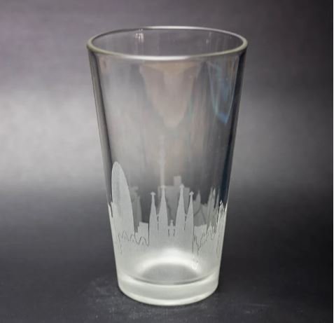 A pint glass with the skyline of Barcelona etched